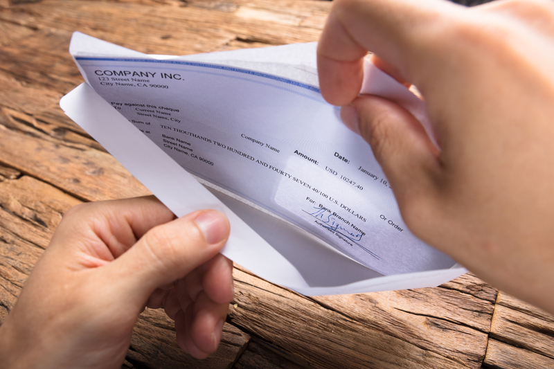 businessman opening envelope with paycheck