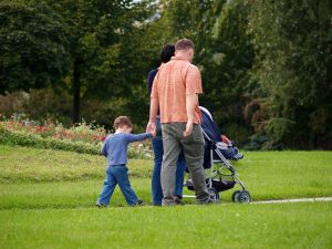 father,mother and two kids, enjoying Sunday afternoon walking in park