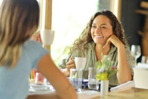 Two women talking drinking coffee in a restaurant